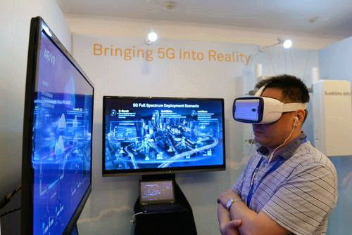 嘉賓在峰會現場利用VR設備觀看5G測試外場。